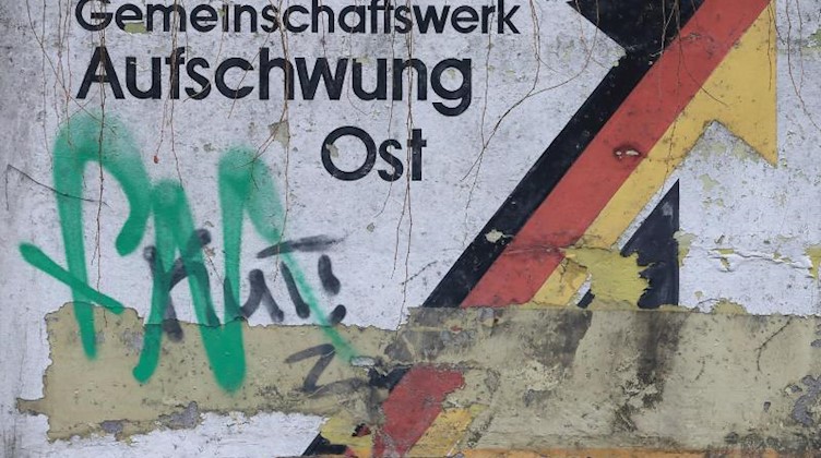 Der verwitterte Schriftzug «Gemeinschaftswerk Aufschwung Ost» in Magdeburg. Fot: Jens Wolf/Archivbild Foto: Jens Wolf