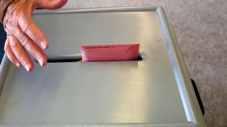 Ein Stimmzettel wird in eine Wahlurne geworfen. Foto: Bernd Wüstneck/Archivbild