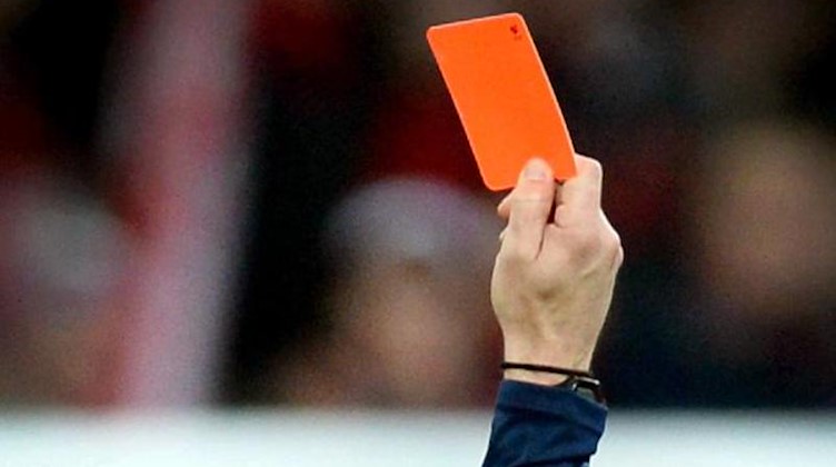 Ein Schiedsrichter zeigt die rote Karte. Foto: Patrick Seeger/Archivbild