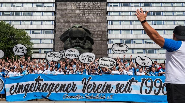 Fans des Chemnitzer FC demonstrieren vor Beginn des Spiels vor dem Karl-Marx-Monument für den Erhalt des Vereins. Foto: Robert Michael