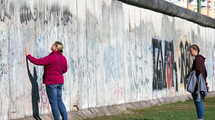 Touristen besuchen die Mauergedenkstätte an der Bernauer Straße in Berlin. Foto: Jens Büttner/Archivbild