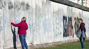Touristen besuchen die Mauergedenkstätte an der Bernauer Straße in Berlin. Foto: Jens Büttner/Archivbild