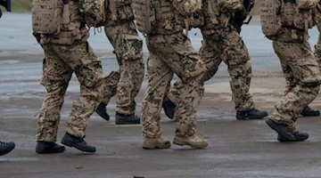 Soldaten der Bundeswehr gehen während einer Übung hinter einander her. Foto: Philipp Schulze/Archiv