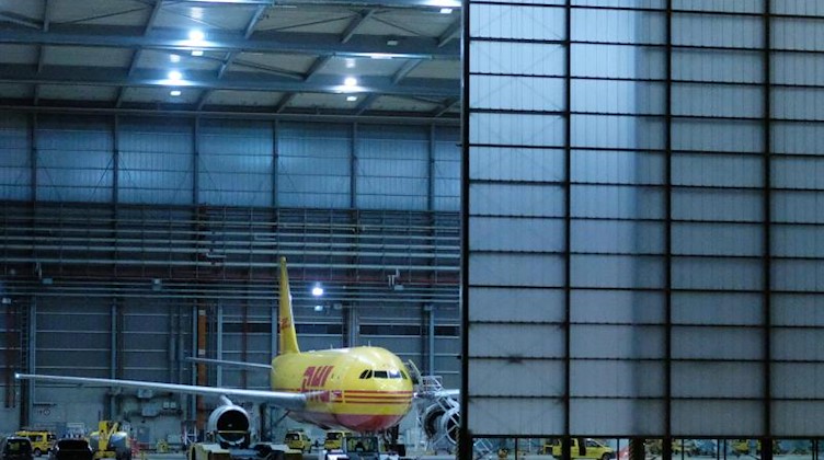 Eine Transportmaschine des Logistikunternehmens DHL steht im Flughafen Leipzig/Halle in einem Hangar. Foto: Sebastian Willnow