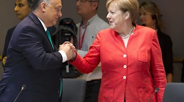 Bundeskanzlerin Angela Merkel (CDU) begrüßt Viktor Orban, Ministerpräsident von Ungarn. Foto: Virginia Mayo/AP/Archivbild