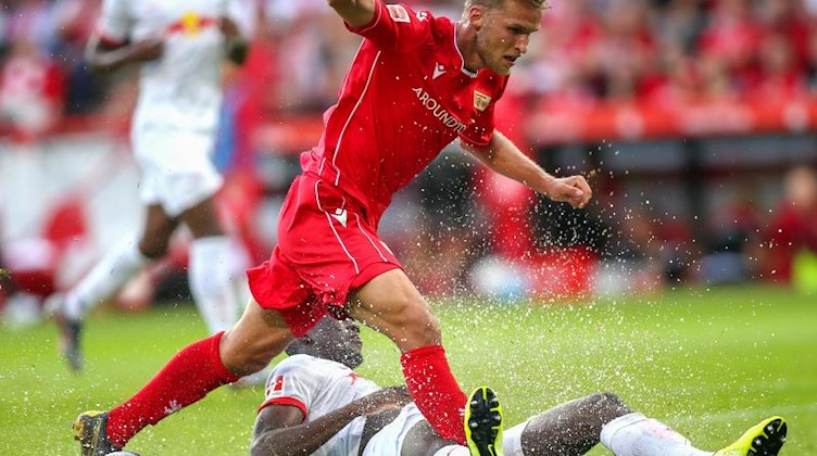 Berlins Sebastian Andersson (l.) stolpert im Kampf um den Ball über Ibrahima Konaté von RB Leipzig. Foto: Andreas Gora