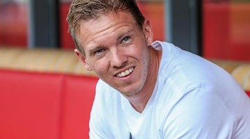 Leipzigs Trainer Julian Nagelsmann sitzt lachend auf der Trainerbank. Foto: Andreas Gora/Archivbild