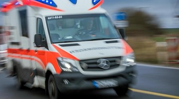 Ein Rettungswagen mit Blaulicht fährt über eine Straße. Foto: Jens Büttner/Archiv