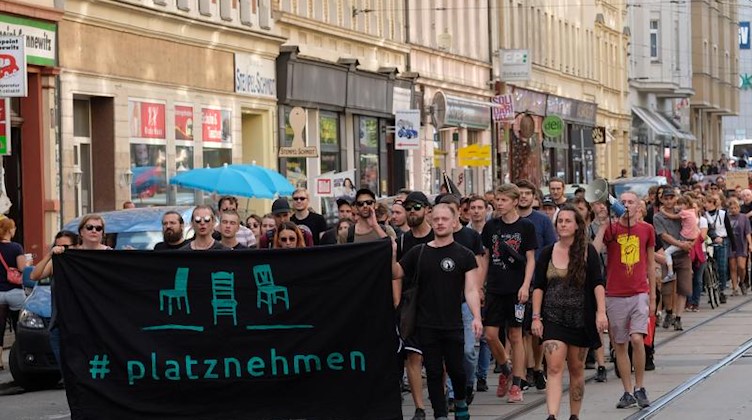Teilnehmer einer linken Demonstration gehen mit Transparenten eine Straße im Stadtteil Connewitz entlang. Foto: Sebastian Willnow