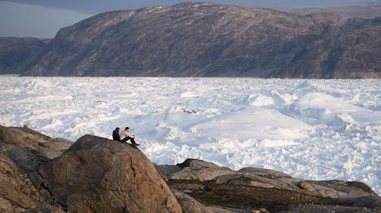 Studentische Forscher blicken über den Gletscher Helheim. Foto: Felipe Dana/AP/Archivbild