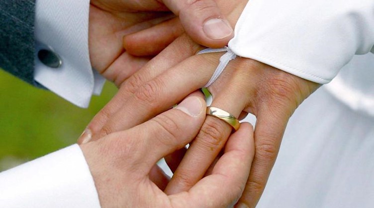 Bei der Trauung streift der Bräutigam der Braut einen Ehering über den Ringfinger. Foto: Andreas Lander/Archivbild
