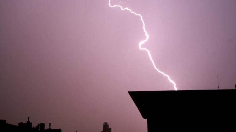 Blitze leuchten während eines Gewitter am Himmel. Foto: Julian Stratenschulte/Archivbild