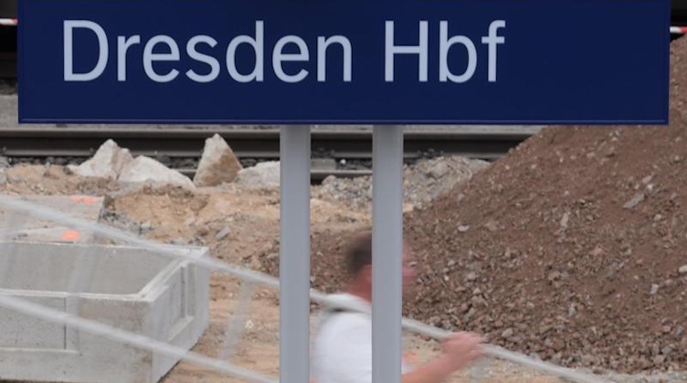 Ein Bauarbeiter trägt auf einem Bahnsteig im Hauptbahnhof Dresden eine Leiter. Foto: Sebastian Kahnert/Archivbild