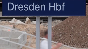 Ein Bauarbeiter trägt auf einem Bahnsteig im Hauptbahnhof Dresden eine Leiter. Foto: Sebastian Kahnert/Archivbild