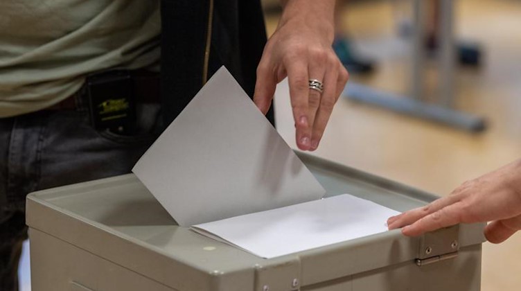 Ein Wähler wirft bei seiner Stimmabgabe zur Landtagswahl in Sachsen den Wahlzettel in einem Wahllokal in eine Wahlurne. Foto: Robert Michael