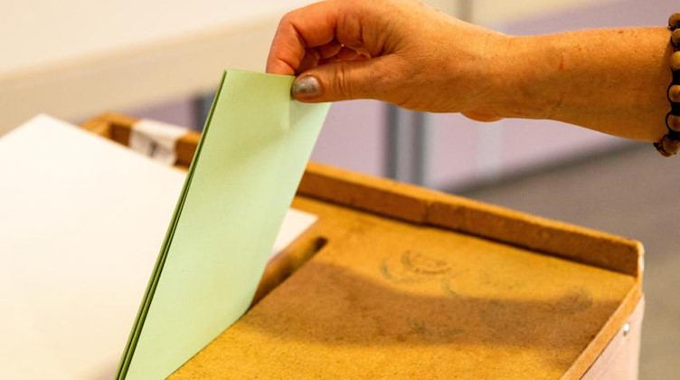Eine Frau wirft ihren Stimmzettel zur Landtagswahl in die Wahlurne. Foto: Daniel Schäfer
