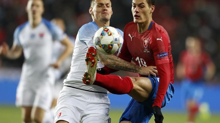 Der Slowake Martin Skrtel (l.) und der Tscheche Patrik Schick (r.) kämpfen in einem Länderspiel um den Ball. Foto: Petr David Josek/AP