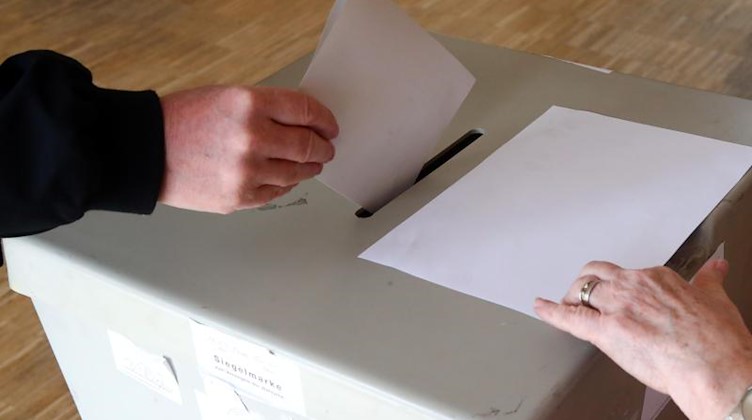 Eine Wählerin wirft ihren Wahlschein in einem Wahllokal in die Wahlurne. Foto: Bodo Schackow/Archiv