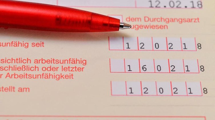 Eine Arbeitsunfähigkeitsbescheinigung liegt auf einem Tisch. Foto: Patrick Pleul/Archivbild