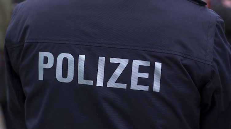 Der Schriftzug "Polizei" ist auf einer Uniform zu sehen. Foto: Jens Büttner/Archivbild