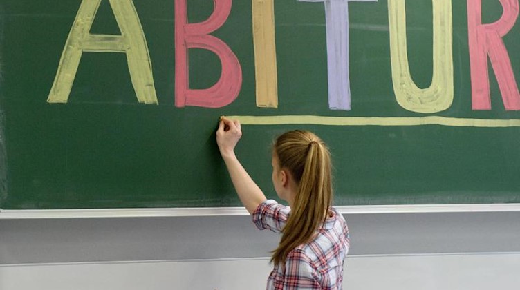 Eine Schülerin unterstreicht das Wort «Abitur» an der Tafel. Foto: Tobias Kleinschmidt/Archivbild