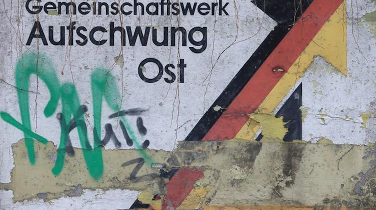 Der teilweise verwitterte Schriftzug "Gemeinschaftswerk Aufschwung Ost". Foto: Jens Wolf/Archivbild