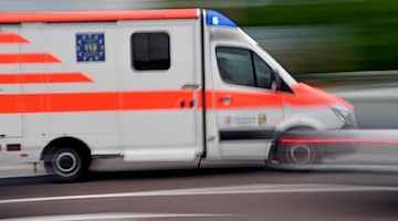 Ein Krankenwagen fährt mit Blaulicht über eine Straße. Foto: Hendrik Schmidt/Archivbild
