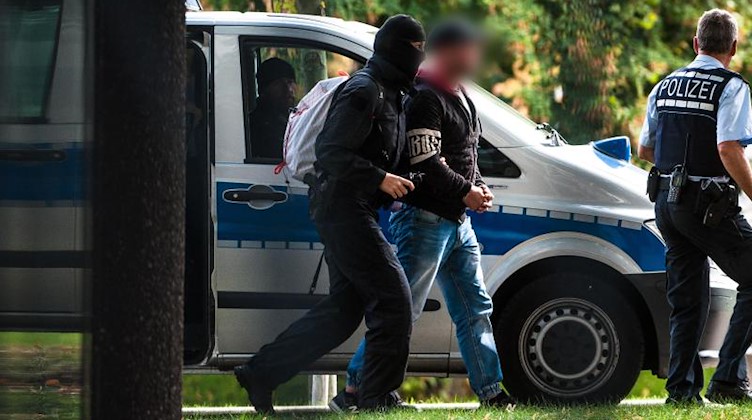 Einer der Rechtsterroristen, die in Bayern und Sachsen festgenommen wurden wird von Polizisten abgeführt. Foto: Christoph Schmidt/Archivbild