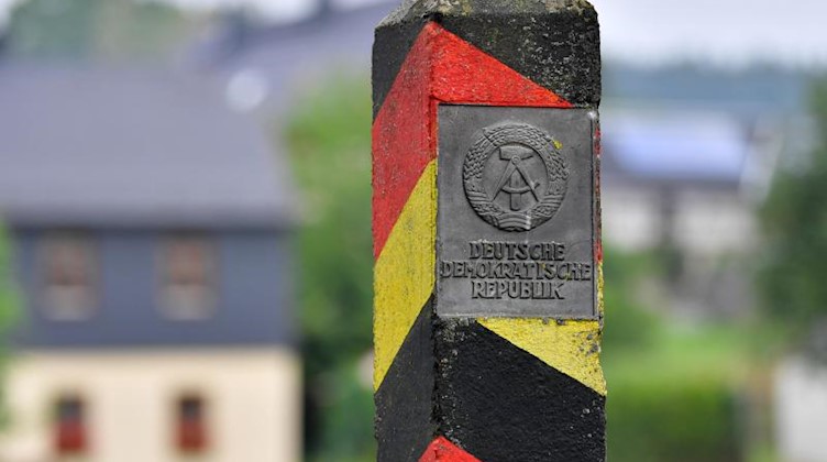 Ein Grenzpfahl mit dem Wappen und dem Schriftzug «Deutsche Demokratische Republik». Foto: Martin Schutt/Archivbild
