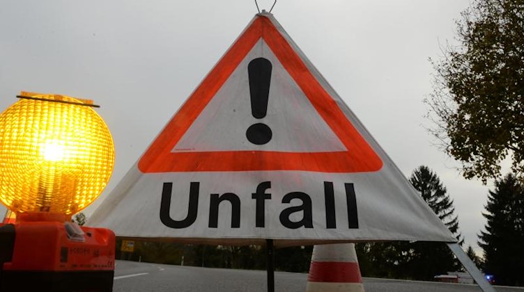 Ein Warndreieck mit der Aufschrift «Unfall» steht auf der Straße. Foto: Patrick Seeger/Archivbild