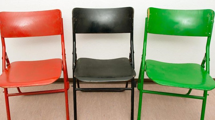Drei Stühle in den Farben rot, schwarz und grün. Foto: Patrick Pleul/Archivbild