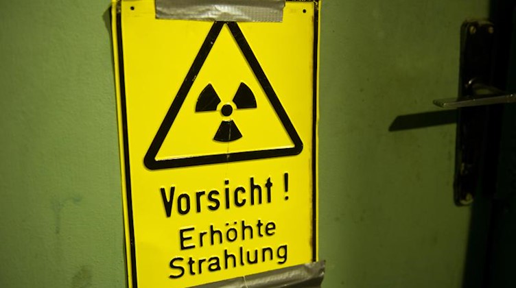 Ein Warnschild mit der Aufschrift «Vorsicht ! Erhöhte Strahlung» klebt an einer Tür. Foto: Stefan Sauer/Archivbild