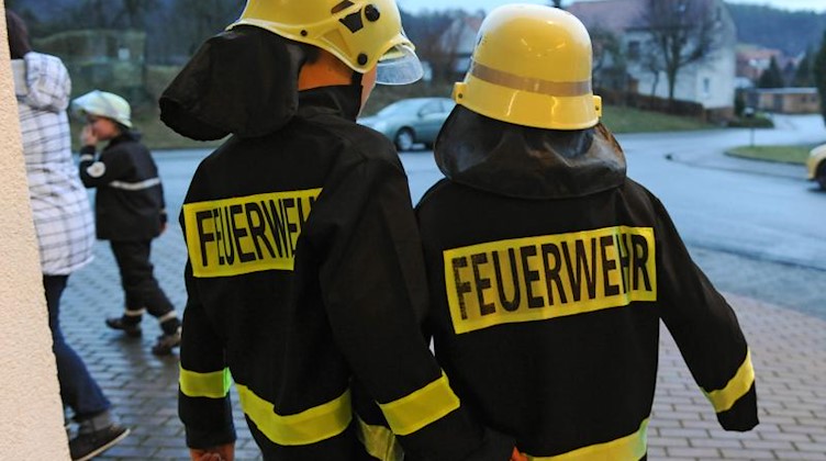 Mitglieder einer Kinderfeuerwehr laufen während einer Unfall-Übung aus dem Feuerwehrhaus. Foto: Uwe Zucchi/Archivbild