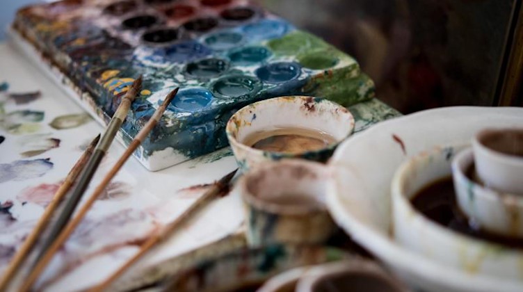 Farben und Pinsel liegen in der Werkstatt einer Porzellanmalerin in der Porzellan-Manufaktur Meißen. Foto: Monika Skolimowska/Archivbild