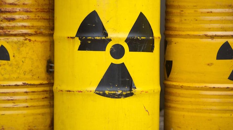 Gelben Tonnen und dem Radioaktiv-Zeichen stehen in Gorleben bei einer Demonstration. Foto: Sebastian Kahnert/Archivbild