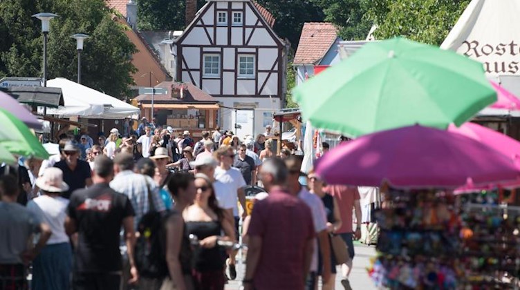 Besucher des Elbhangfests gehen an Verkaufsständen entlang. Foto: Sebastian Kahnert/Archivbild