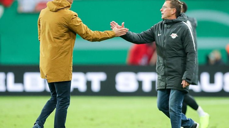 Ralf Rangnick (r) und Hoffenheims Trainer Julian Nagelsmann geben sich die Hand. Foto: Jan Woitas/Archiv