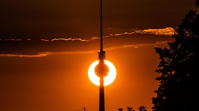 Der Berliner Fernsehturm vor der untergehenden Sonne. Foto: Paul Zinken/Archivbild