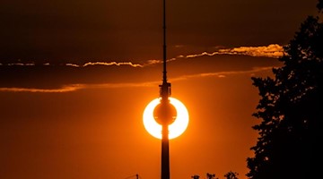 Der Berliner Fernsehturm vor der untergehenden Sonne. Foto: Paul Zinken/Archivbild