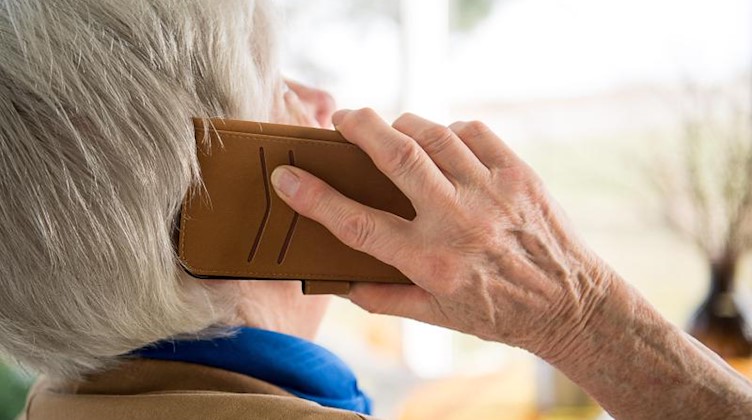 Eine Seniorin telefoniert mit ihrem Smartphone. Foto: Sebastian Gollnow/dpa