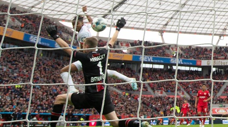 Leipzigs Christopher Nkunku erzielt das 1:1 gegen Leverkusens Torwart Lukas Hradecky. Foto: Federico Gambarini/dpa