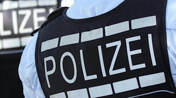 In Polizei-Westen gekleidete Polizisten stehen am Straßenrand. F. Foto: Silas Stein/dpa