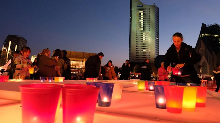 Leipziger und Gäste der Stadt stellen auf dem Augustusplatz Kerzen auf. Foto: Sebastian Willnow/zb/dpa