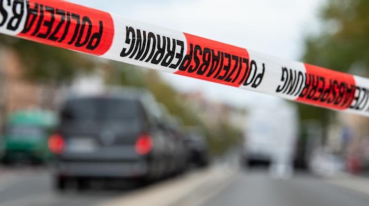 Absperrband der Polizei ist in einer Hauptstraße vor Einsatzfahrzeugen zu sehen. F. Foto: Swen Pförtner/dpa