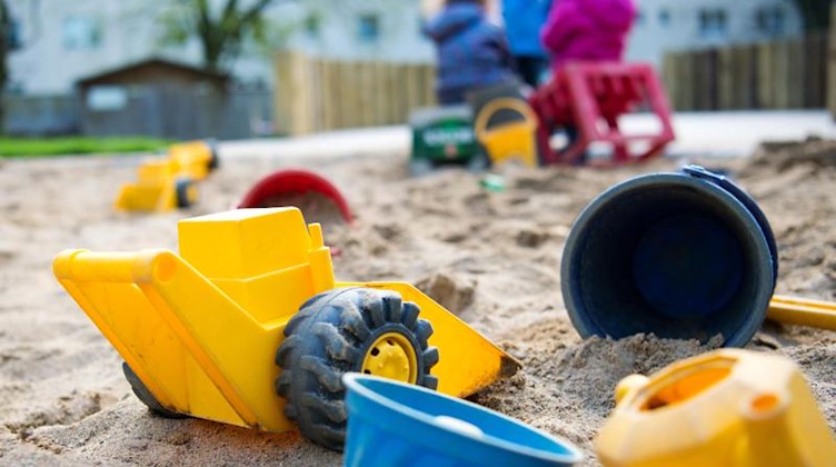 Spielzeug liegt in einem Sandkasten in einer Kindertagesstätte. Foto: Monika Skolimowska/dpa