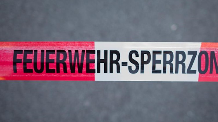 Ein Absperrband mit der Aufschrift "Feuerwehr-Sperrzone". Foto: Daniel Bockwoldt/dpa