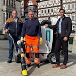 (V.li.) Ralf Günther, Leiter des städtischen Bauhofs, Maik Dobbrik, Mitarbeiter des Bauhofs, und Bürgermeister Tobias Dannenberg inspizieren auf dem Rathausvorplatz das neue Reinigungsfahrzeug der Stadt. Foto: Simon