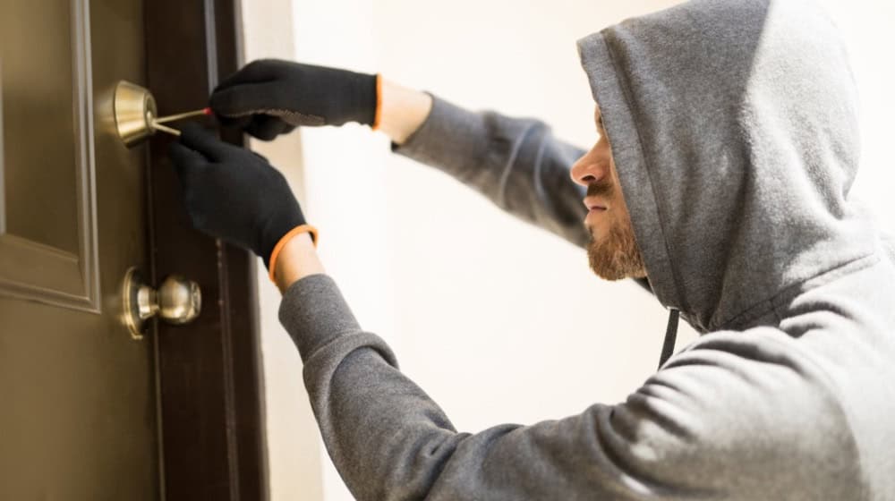Ein Einbrecher beim Öffnen einer Haustür. Foto Freepik