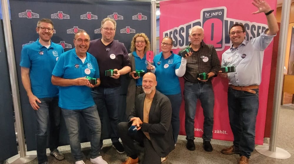 Das erfolgreiche Team des Werra-Meißner-Kreises (v. l.): Sebastian Brötz, Reiner Winkler, Mark Thielmann, Anja Schaffer, Claudia Enge, Frank Köhne und Oliver Manegold mit hr-iNFO-Moderator Ulli Janovsky bei der Siegerehrung des „BesserQwisser“-Finales. Foto: WMK