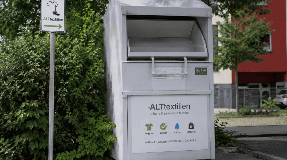 Seit Juli ist die Alttextiliensammlung in Witzenhausen neu organisiert. Gebündelte Standorte und angepasste Leerungsintervalle sollen überfüllte Container künftig vermeiden. Symbolbild, mit KI generiert.
